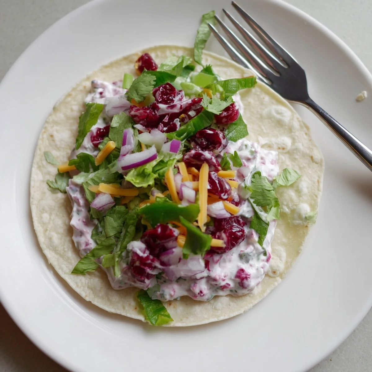 Savory Cranberry Jalapeño Dip tacos topped with fresh cilantro and vibrant red onions.