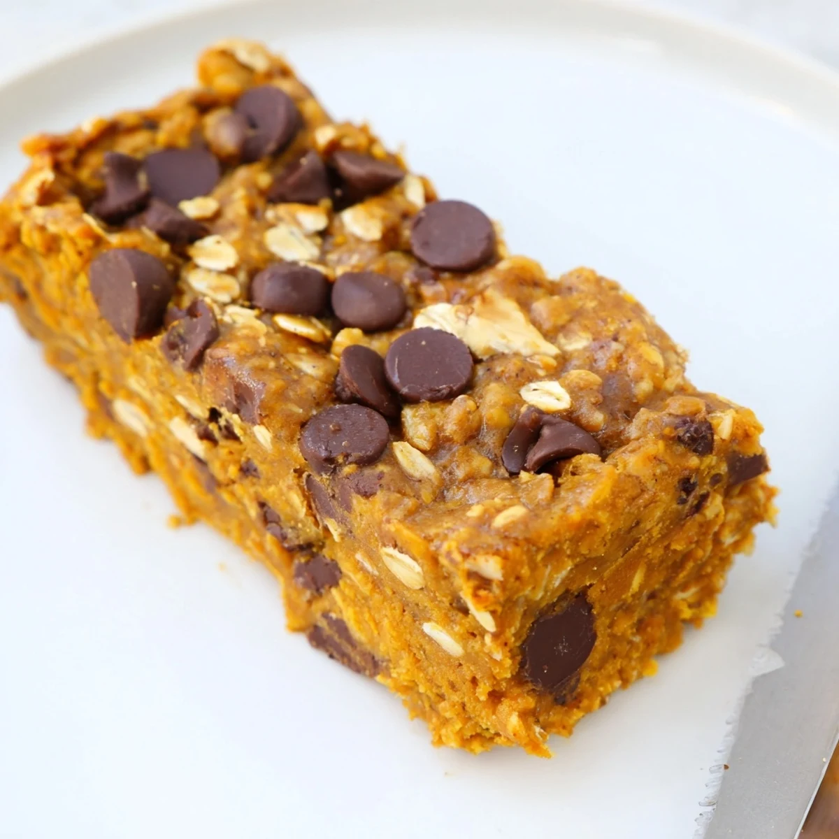 Decadent pumpkin muffin protein bars topped with walnuts and chocolate chips.  