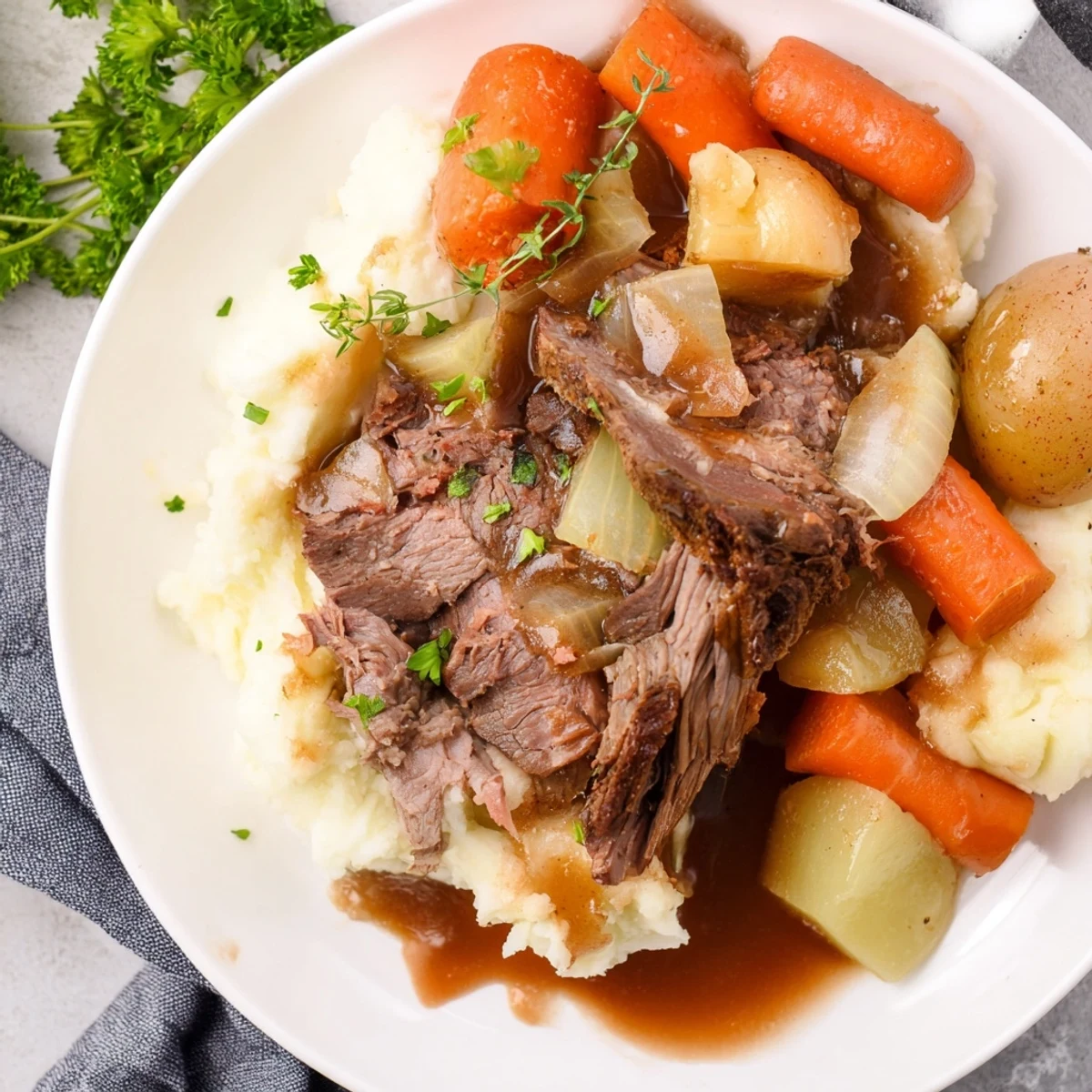 Slow Cooker Pot Roast with Mashed Potatoes served with rich gravy and vibrant vegetables.