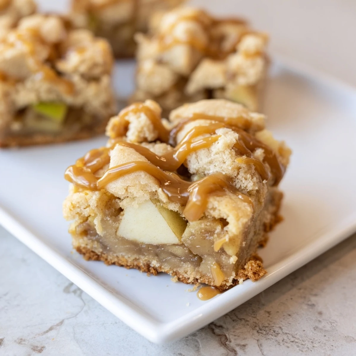 Warm, inviting photo of freshly baked caramel apple cookie bars, brimming with gooey caramel.