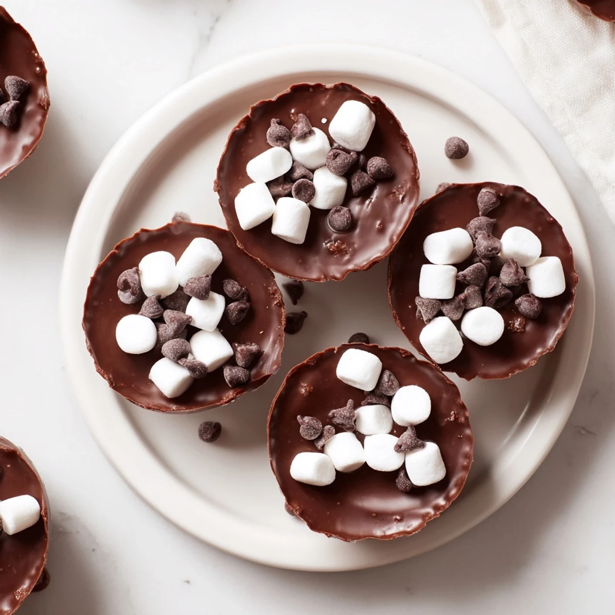 Melted chocolate cradles hot cocoa mix and mini marshmallows in a hot cocoa bomb cup.