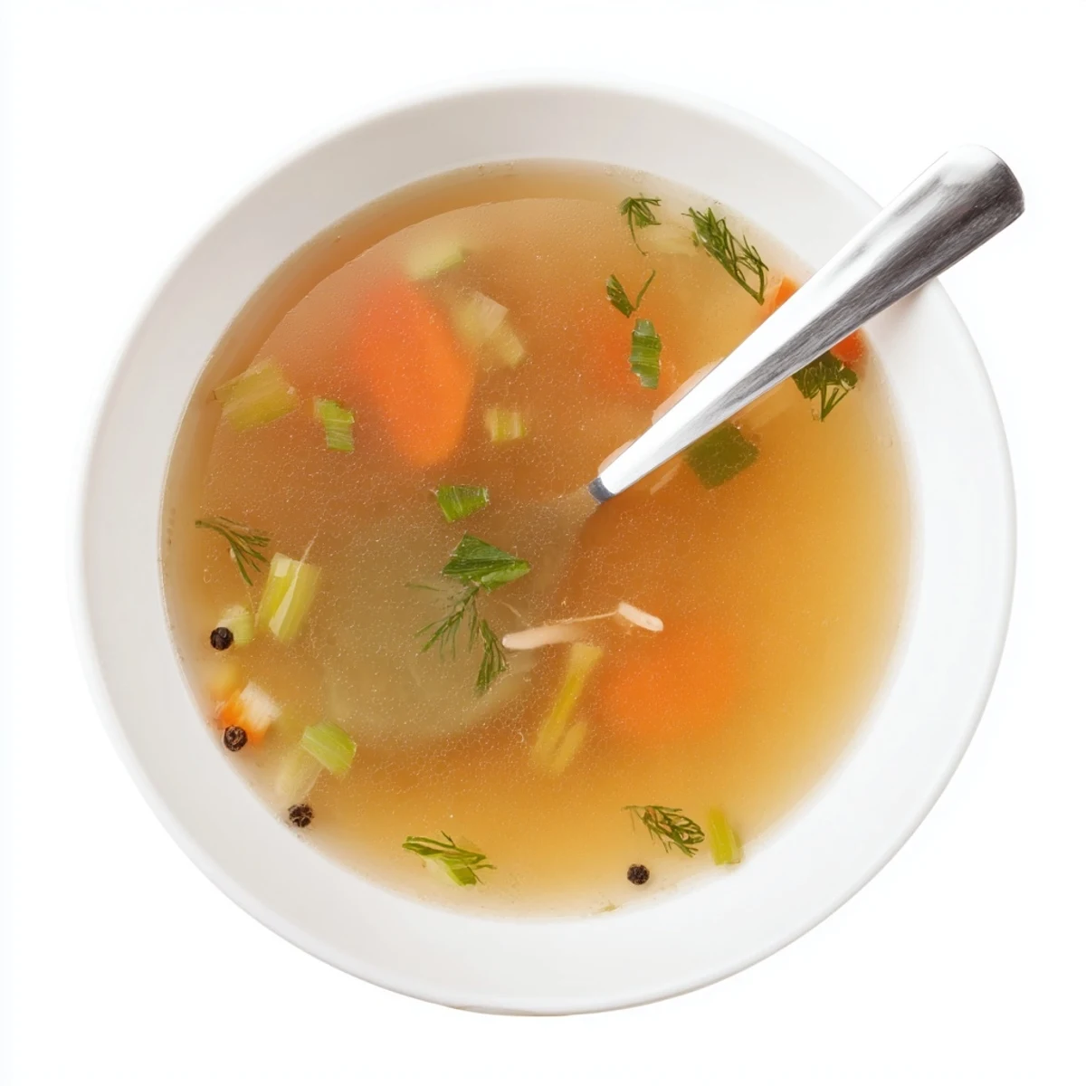 A fine-mesh sieve straining vibrant Vegetable Broth From Scraps into a glass bowl, showcasing its clear, light color.