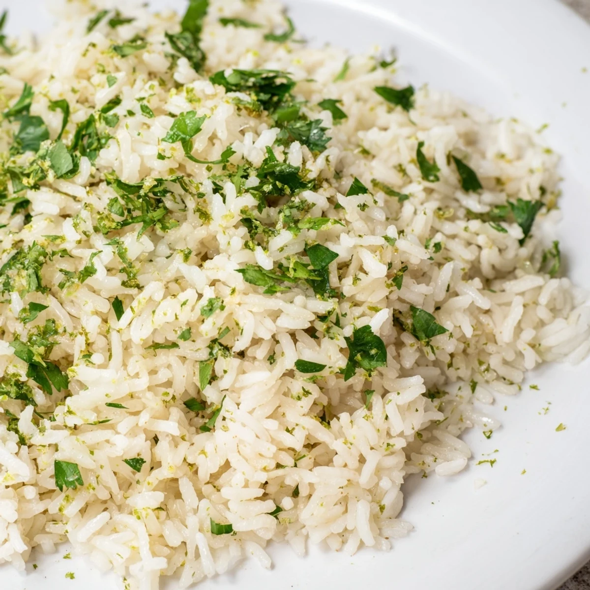 A serving bowl of aromatic Cilantro Lime Rice topped with extra cilantro and a lime wedge, ready to pair with tacos.