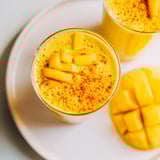 A close-up of a refreshing Mango Turmeric Smoothie, blended to a smooth, golden perfection in a glass.