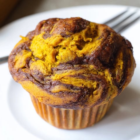 Moist gingerbread pumpkin muffin swirls topped with spiced gingerbread for festive delight.  