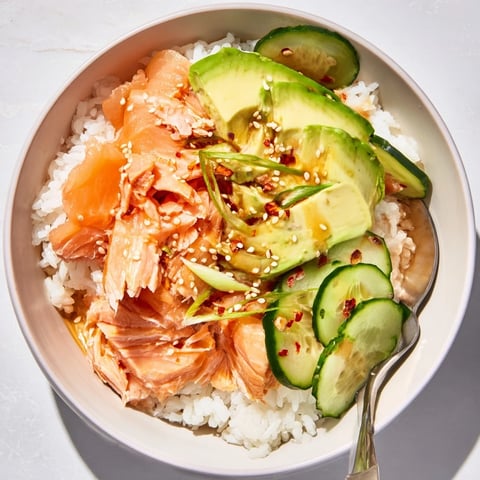 Delicious leftover salmon and rice bowl topped with fresh vegetables and soy sauce.  