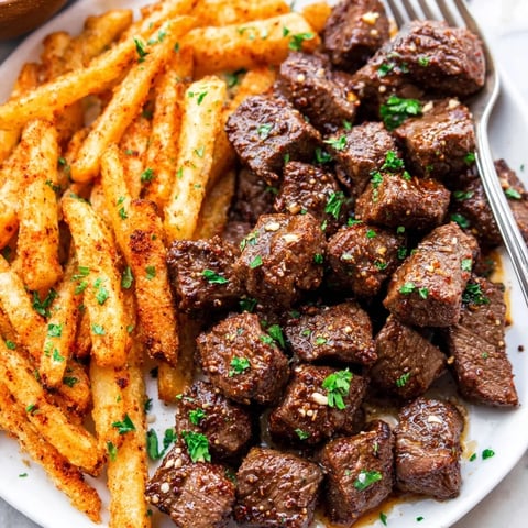 Juicy blackened Cajun steak bites served hot with golden, crispy fries.  