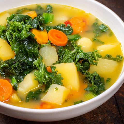 Steaming bowl of Vegetarian Potato-Kale Soup, garnished, ready to warm you on a chilly evening.