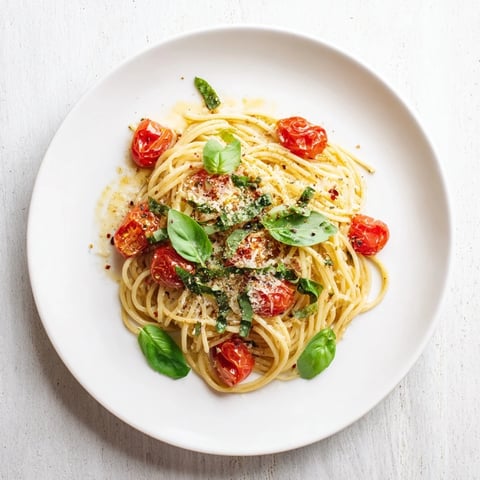 Golden, fragrant Lazy-Girl Pasta with glistening tomatoes and a sprinkle of Parmesan ready to serve.