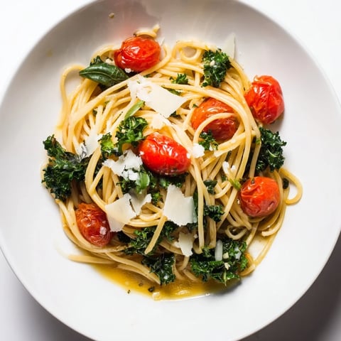 Steaming one-pot spaghetti with kale boasts vibrant tomatoes, herbs, and perfectly cooked pasta for dinner.