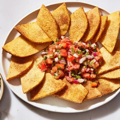 Golden, crispy air-fryer tortilla chips ready to be dipped into a vibrant fresh salsa.