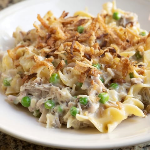 Golden-brown tuna noodle casserole boasting a crispy onion topping, perfect for sharing at dinner.
