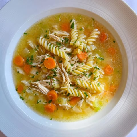 Warm, inviting bowl of Crockpot Chicken Noodle Soup, steam rising from the comforting broth, ready to eat.