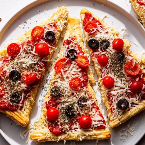 Golden, cheesy puff pastry Christmas tree pizza bites, perfect for a festive holiday appetizer.