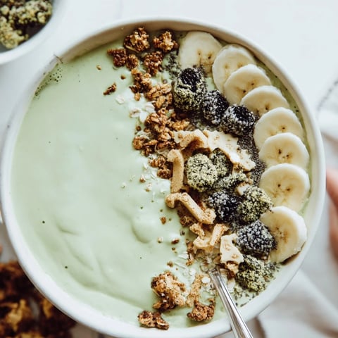 Vibrant Gingerbread Cookie Matcha Breakfast Smoothie Bowl topped with colorful granola and fresh berries.