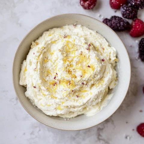 Fluffy Cream Cheese Fruit Dip, overflowing with fresh berries--a creamy, sweet, and tangy treat.