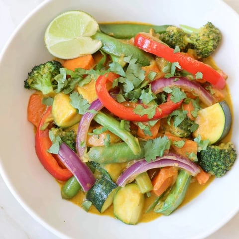 Steaming Coconut Curry Vegetables with vibrant colors; bell peppers, carrots, and broccoli bathed in coconut sauce.