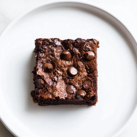 Fudgy Greek yogurt brownies, warm from the oven, with melting chocolate chips and a rich aroma.