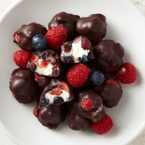 Refreshing chocolate yogurt clusters, studded with berries, offer a delightful frozen dessert experience.