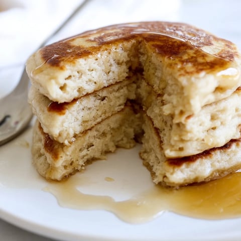 Golden-brown Protein Banana Pancakes, ready for a satisfying, protein-packed breakfast with fresh fruit.