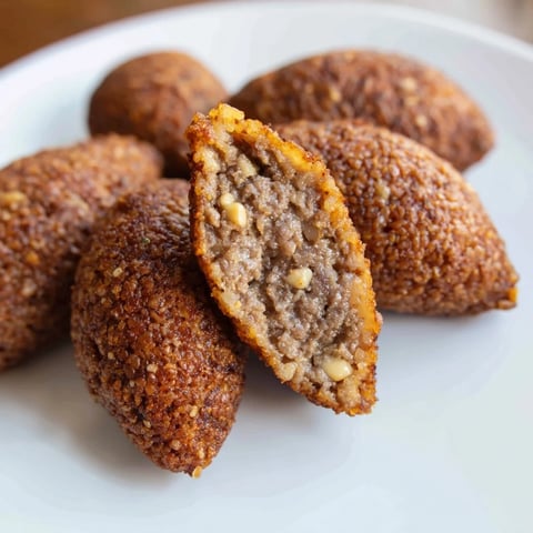 Golden-brown Lebanese Kibbeh, crisp on the outside, showcasing its savory, spiced meat filling within.