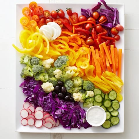 Colorful Vegetable Rainbow Board featuring an array of vibrant, crisp veggies, and creamy hummus for dipping.