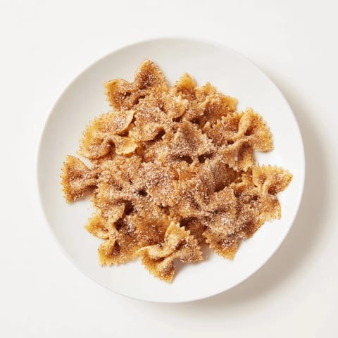 Crunchy, air-fried bowtie pasta forms an irresistible Christmas Crack snack, coated in cinnamon sugar.