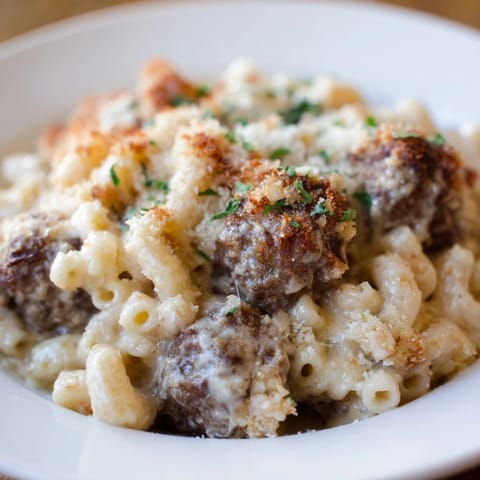 This baked Mac & Cheese Meatball Bake shows a cheesy casserole with perfectly cooked meatballs.