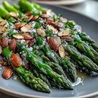 Fresh asparagus spears sautéed in lemon butter, topped with toasted almonds for a bright, elegant side dish.
