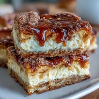 Golden Easy Cinco de Mayo Sopapilla Cheesecake Bars drizzled with sweet cinnamon.